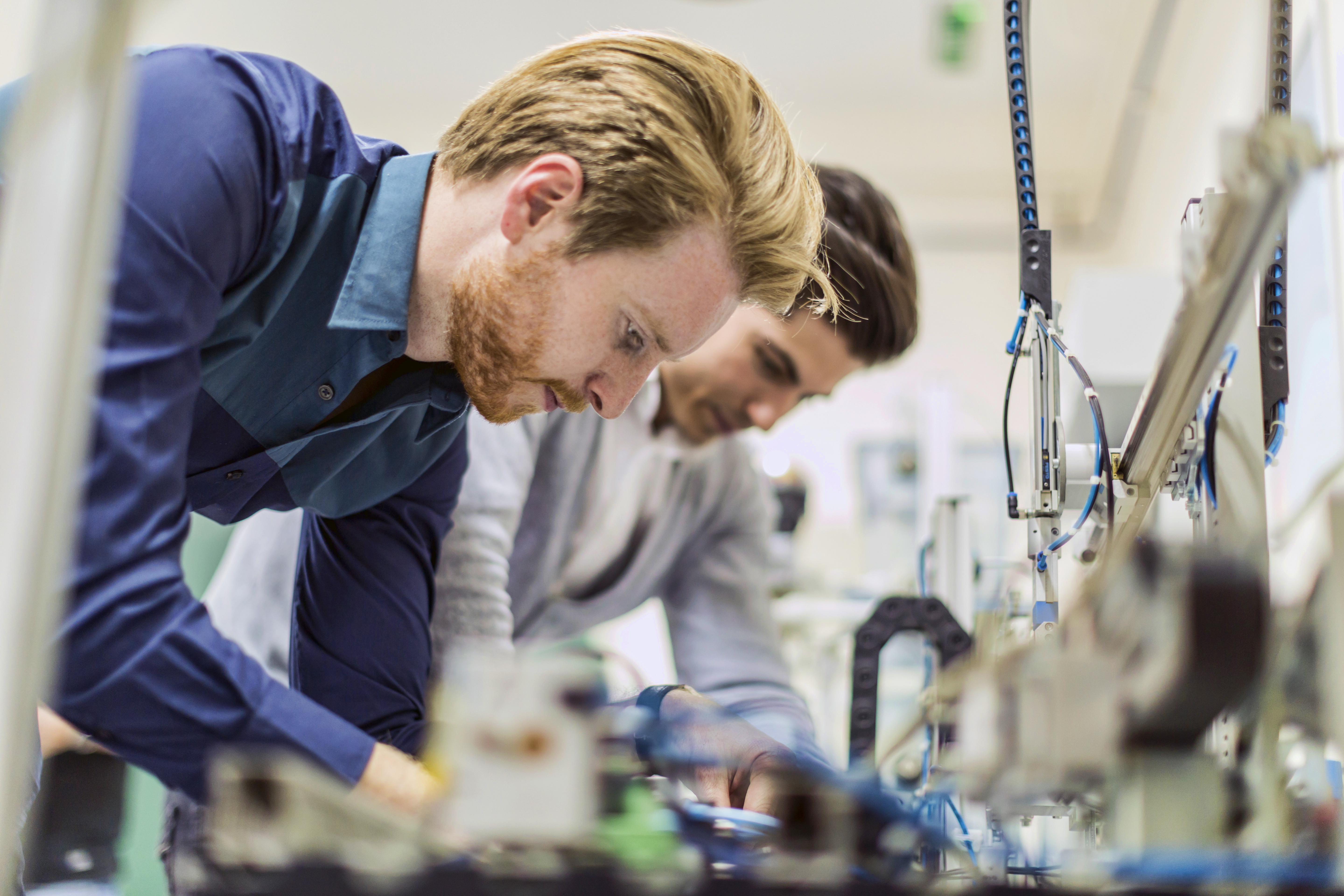 Two young handsome engineers working on electronics components