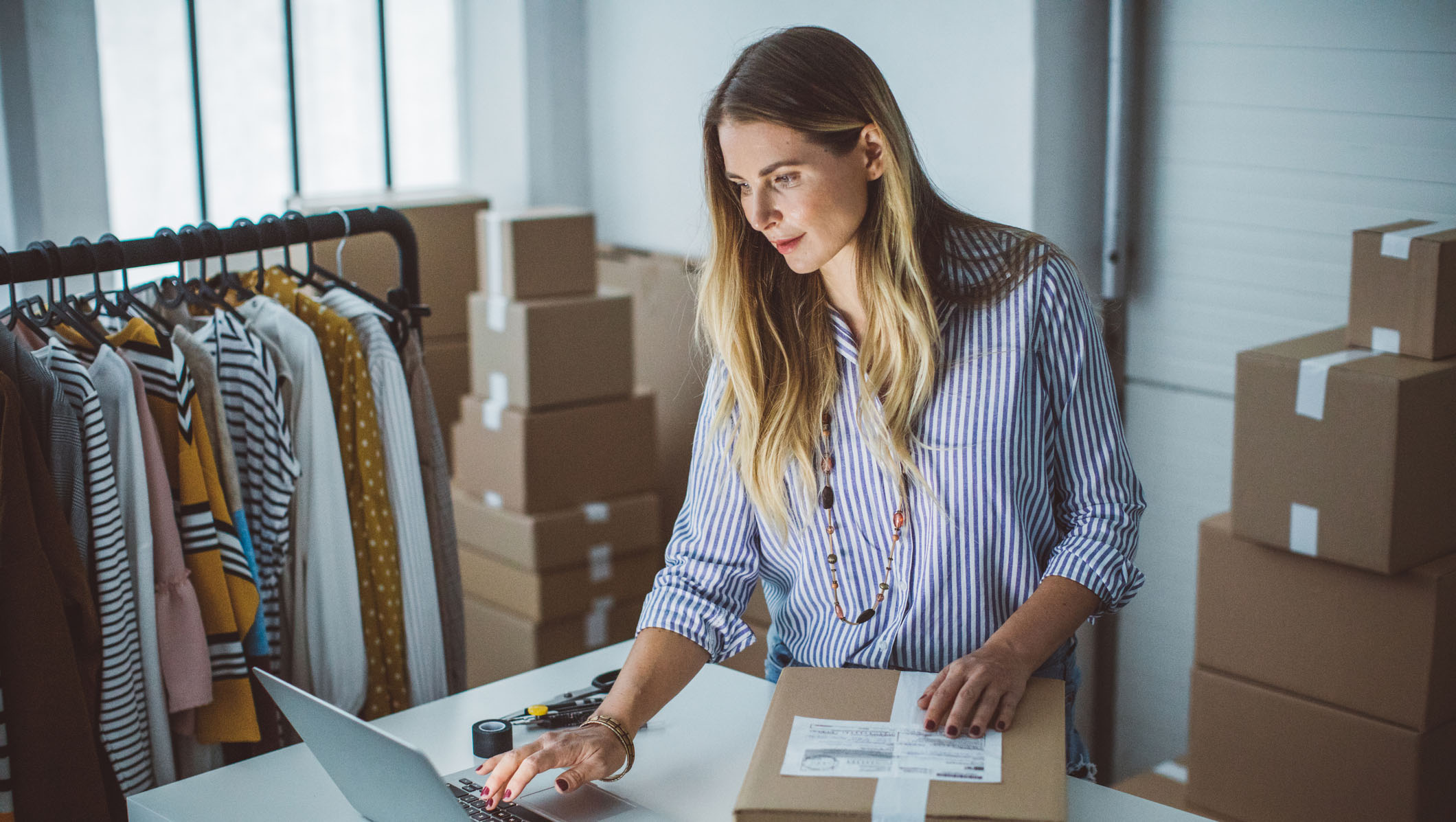 Women, owner of small business packing product in boxes, preparing it for delivery. Women, owner of small business packing product in boxes, preparing it for delivery.