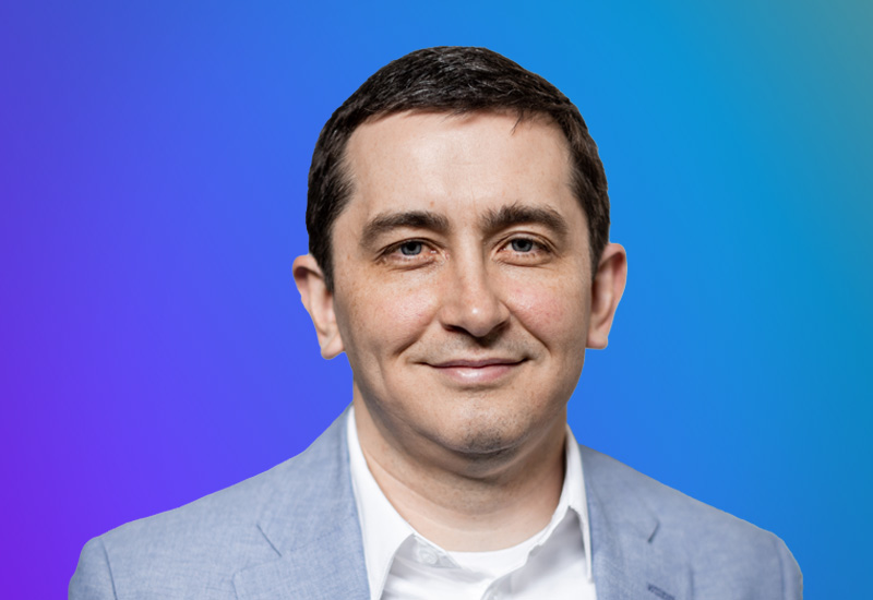 Professional headshot of a speaker at AWS Summit Hamburg in front of a blue gradient background.
