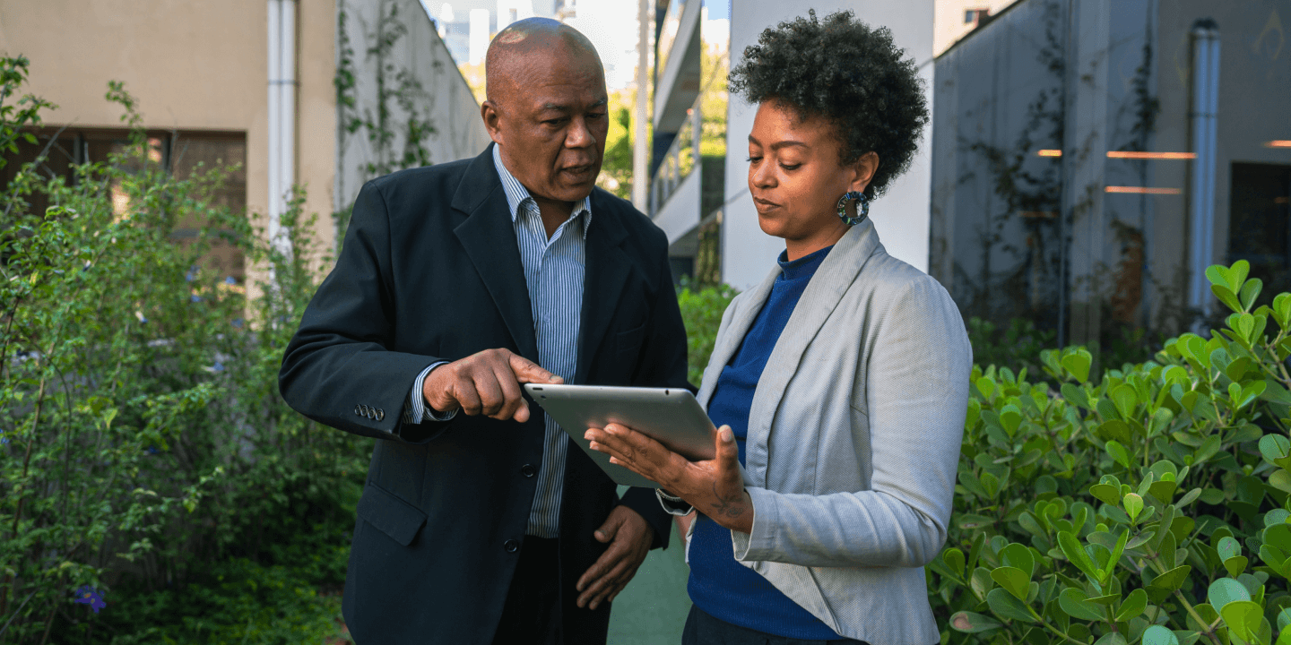 Business leaders looking at a tablet outside the office