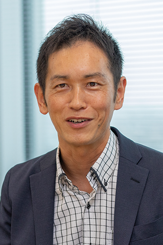 Portrait of a business professional in a suit, photographed in an office setting, representing DENSO for a case study or corporate usage.