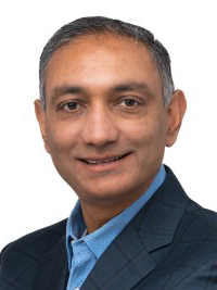 Portrait of a professional individual in a blue suit jacket and light blue shirt, smiling, with a neutral background.